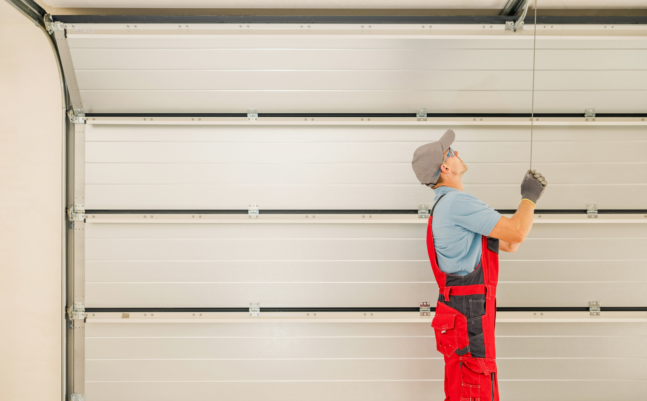 Man checking garage door for what parts to be fixed