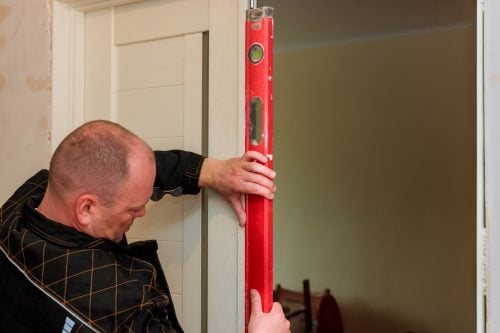 Man measuring the garage door for repair