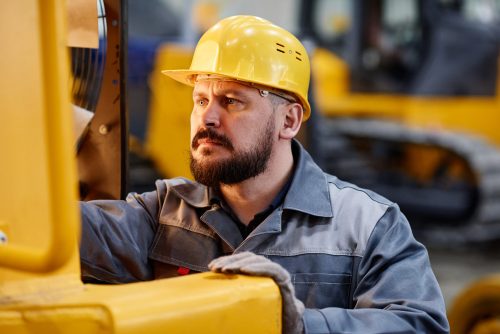 Professional worker assessing garage door springs to know how to improve its performance