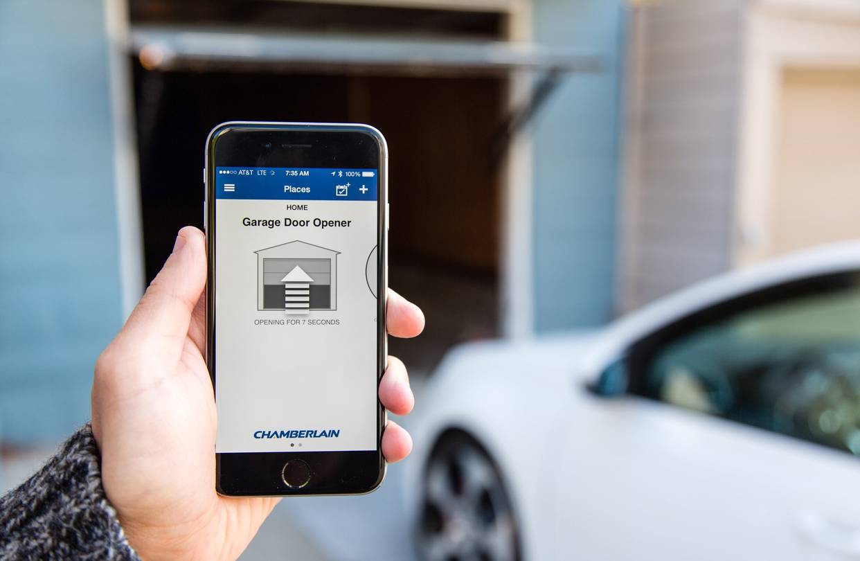 Homeowner Using Smartphone App to Control Modern Garage Door