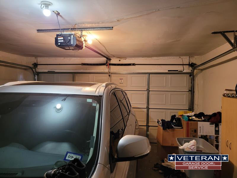 Garage with car, door opener, cluttered space